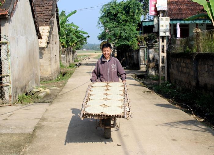 Người dân làng nghề dùng xe rùa chở bánh đi phơi. Ảnh: Huy Thư