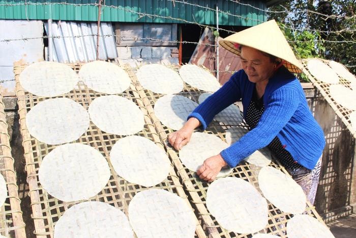 Bánh đa sắn phơi lâu khô hơn bánh đa gạo. Vài tiếng đồng hồ sau khi phơi, bánh sẽ được trở dưới lên trên để khô cho đều. Ảnh: Huy Thư