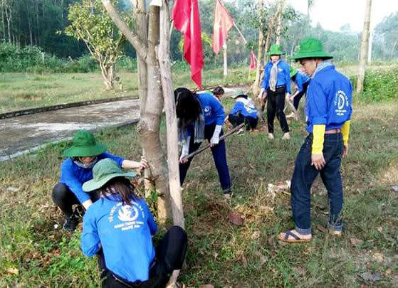 Các tình nguyện viên trồng và chăm sóc cây xanh tại Nghĩa trang liệt sỹ xã Thanh Tùng. Ảnh: Huy Thư