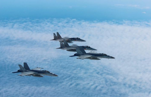 Japans Self-Defense Forces F-15 fighter jets (top and 2nd from top) conduct an air exercise with U.S. Navy F/A 18 Hornet aircrafts in the skies above the Sea of Japan, Japan, in this photo released by the Air Staff Office of the Defense Ministry of Japan November 13, 2017