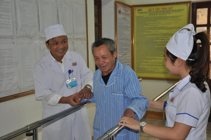 Bác sỹ Bệnh viện PHCN Nghệ An hướng dẫn người bệnh tập đi phục hồi chức năng do tai biến mạch máu não.