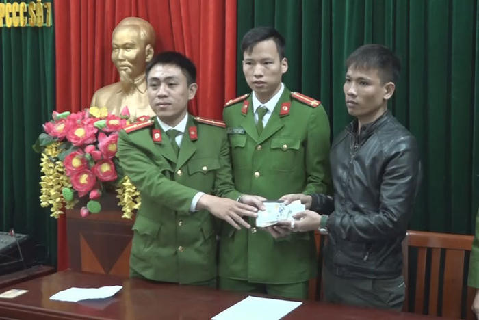 Cơ quan Phòng Cảnh sát chữa cháy số 7 trao trả lại ví cho anh Lê Văn Sơn. Ảnh: Thúy Tình