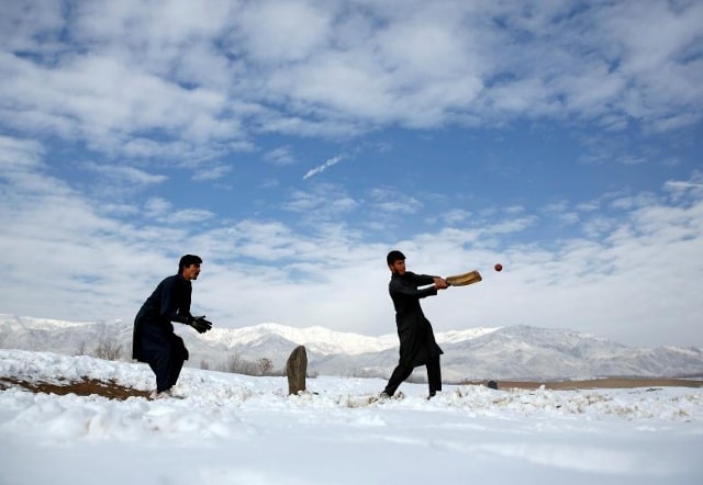 Những người đàn ông Afghanistan chơi cricket trên một cánh đồng tuyết phủ ở ngoại ô Kabul, Afghanistan