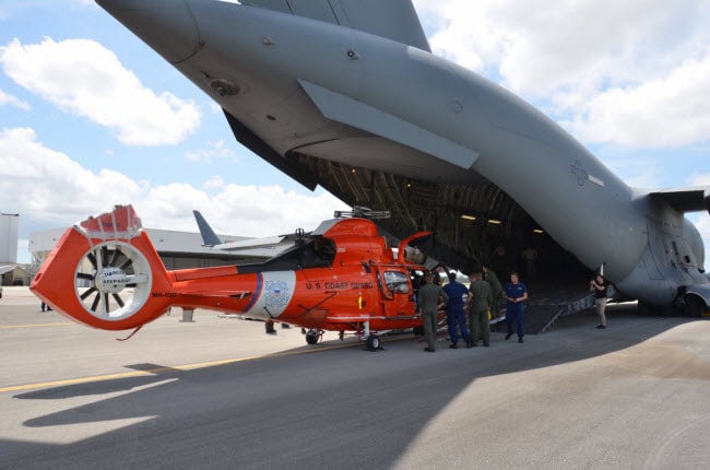 Máy bay trực thăng MH-65 Dolphin được đưa lên máy bay vận tải C-17 của Không quân Mỹ tại trạm bảo vệ bở biển Miami ở Opa Locka, bang Florida.