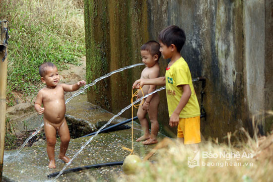 Những đứa trẻ người Mông mình trần chơi đùa bên bể nước ngày lạnh. Ảnh: Đào Thọ