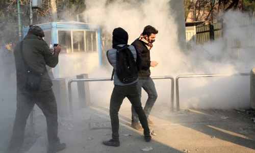 Sinh viên Iran tránh khí hơi cay tại Đại học Tehran trong cuộc biểu tình ở Tehran ngày 30/12. Ảnh: AFP.