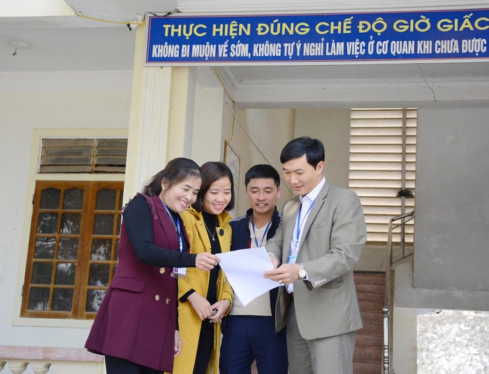 Cán bộ, công chức thị trấn Thanh Chương trao đổi công việc chuyên môn. Ảnh: Thu Giang