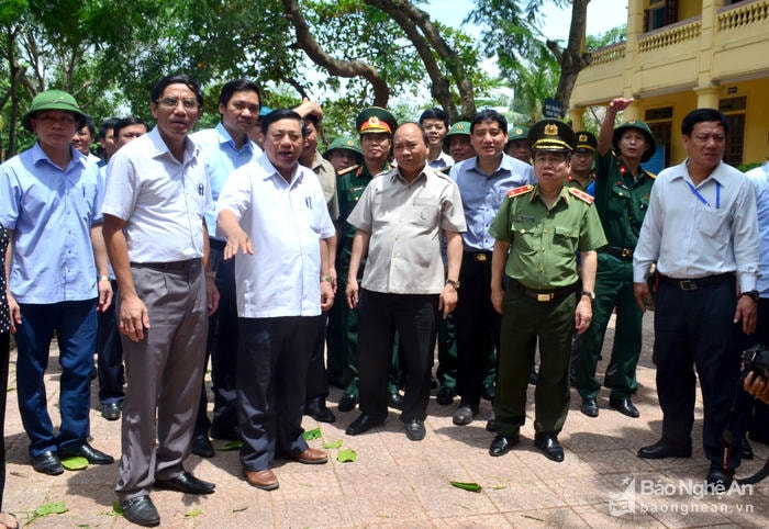 Thủ tướng Nguyễn Xuân Phúc nghe báo cáo tình hình thiệt hại do bão số 10 gây ra tại Trưởng Tiểu học Nghi Hải, thị xã Cửa Lò. Ảnh: Thành Duy