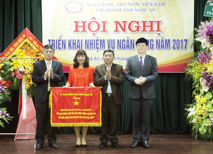 Ngân hàng Nhà nước Chi nhánh Nghệ An đón nhận Cờ thi đua xuất sắc toàn diện, dẫn đầu phong trào thi đua yêu nước do UBND tỉnh trao tặng. Ảnh: Hoàng Vĩnh