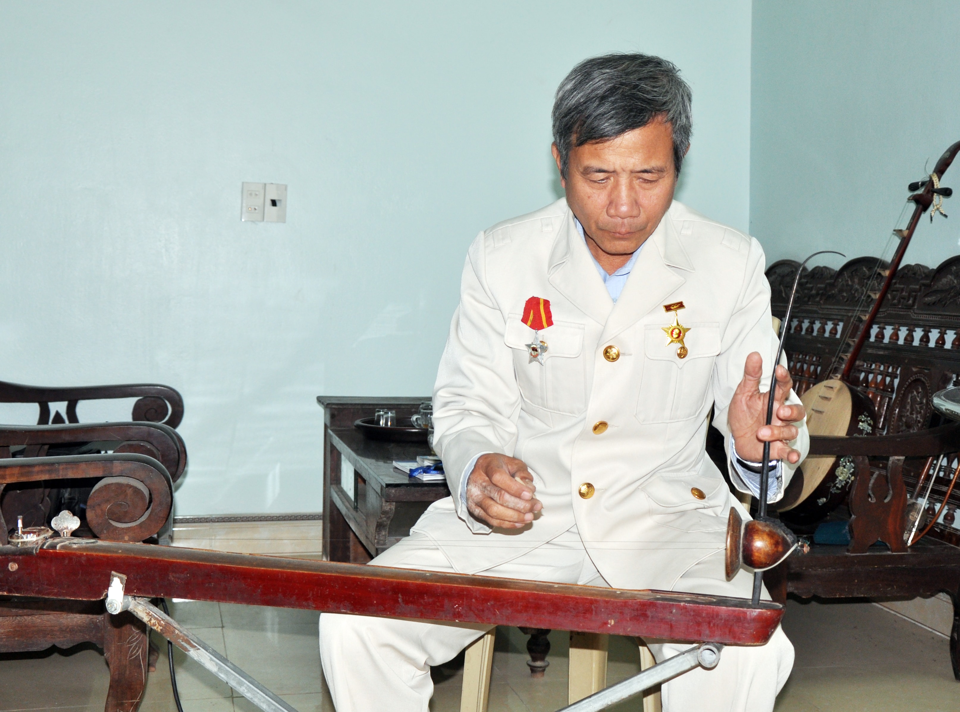 Nghệ nhân Nguyễn Đình Túc bên chiếc đàn bầu