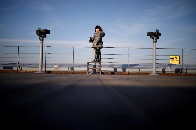 Một cô gái đứng giữa ống nhòm hướng về phía Bắc, gần khu phi quân sự chia cắt hai miền Triều Tiên ở Paju, Hàn Quốc