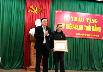 Đồng chí Bùi Thanh Bảo - Bí thư huyện ủy, Chủ tịch HĐND huyện trao Huy hiệu Đảng cho đảng viên. Ảnh: Phương Hảo