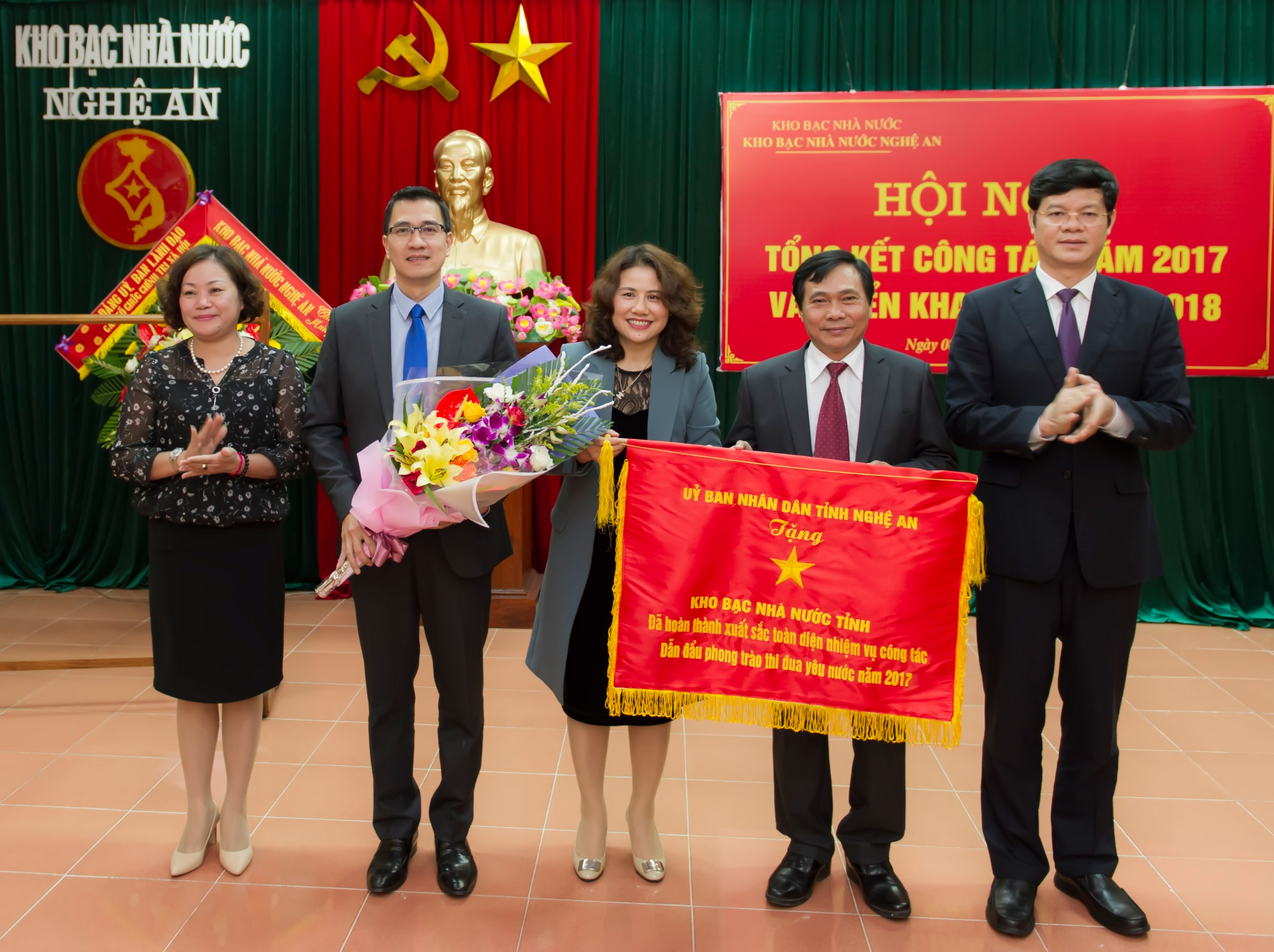 Đồng chí Lê Xuân Đại trao cờ thi đua năm 2017 của UBND tỉnh cho KBNN Nghệ An. Ảnh: TH
