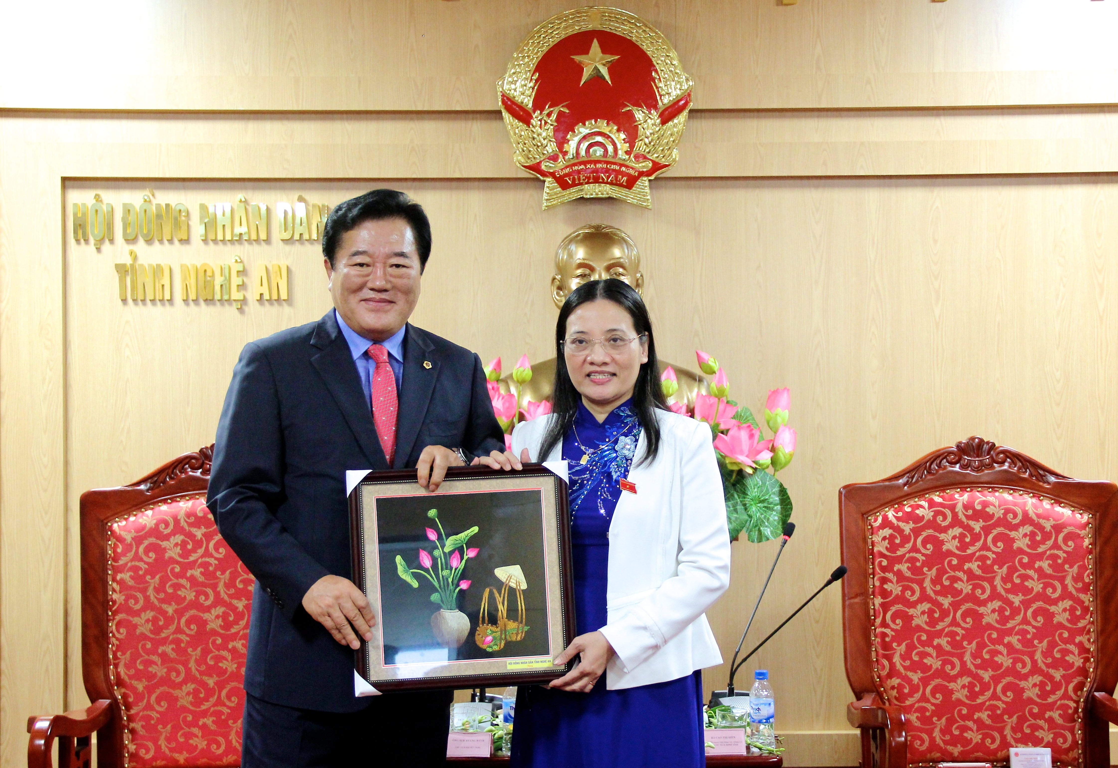 Phó Chủ tịch HĐND tỉnh Nghệ An Cao Thị Hiền tặng bức tranh hoa sen - quốc hoa của Việt Nam cho đoàn đại biểu hội đồng tỉnh Gyeonggi. Ảnh: Mỹ Nga.