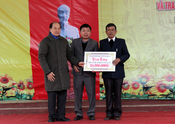 Ông Trần Xuân Bí - Chủ tịch Hội Khuyến học tỉnh trao học bổng cho Quỹ Khuyến học huyện Nghĩa Đàn.