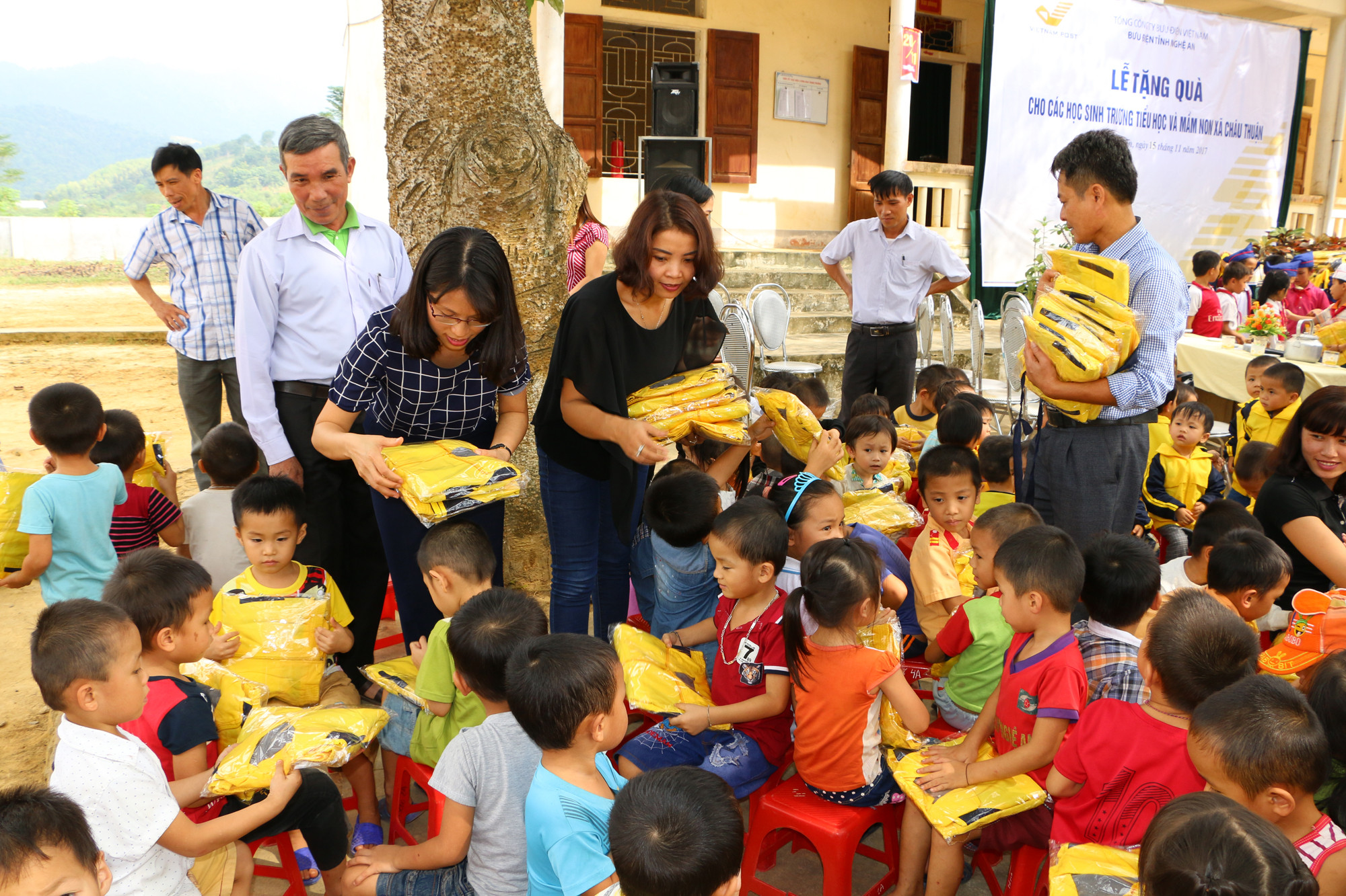 Bà Bùi Thị Minh và đại diện Công đoàn Bưu điện tỉnh trao quà cho học sinh nghèo xã Châu Thuận, Quỳ Châu. Ảnh: Nguyễn Hải