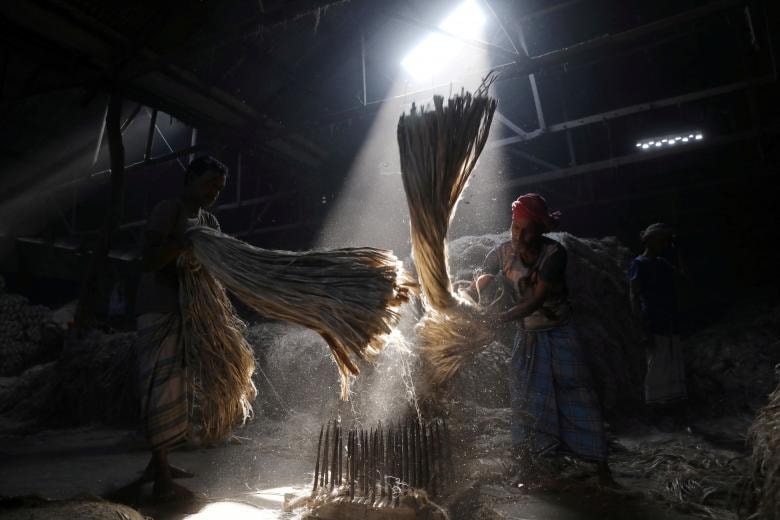 Sunrays đi xuyên qua mái nhà khi nhân viên làm việc tại một nhà máy chế biến đay ở Narayanganj gần Dhaka, Bangladesh. REUTERS / Mohammad Ponir Hossain