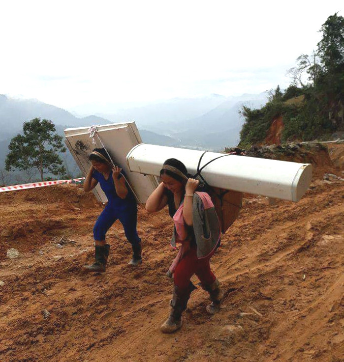 Người dân háo hức giúp  Viettel gùi vận chuyển các thiết bị lên đồi. Ảnh: Hùng Cường