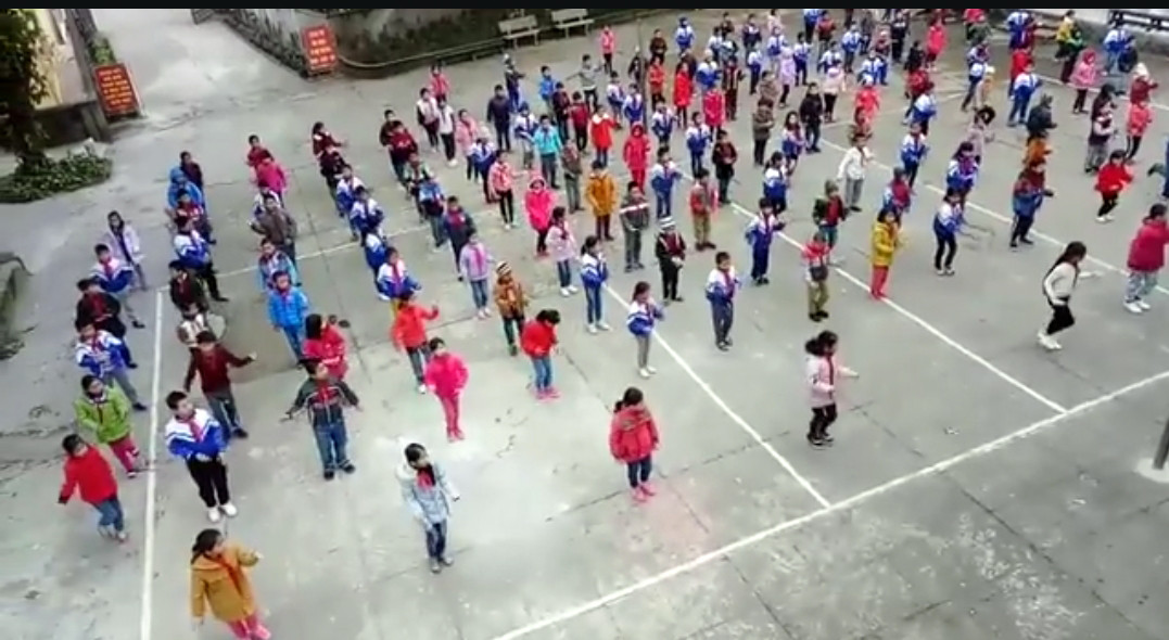Học sinh và cô giáo trường Tiểu học Tam Quang 1 cùng múa bài Sáo Xiêng Khoảng. Ảnh cắt từ clip