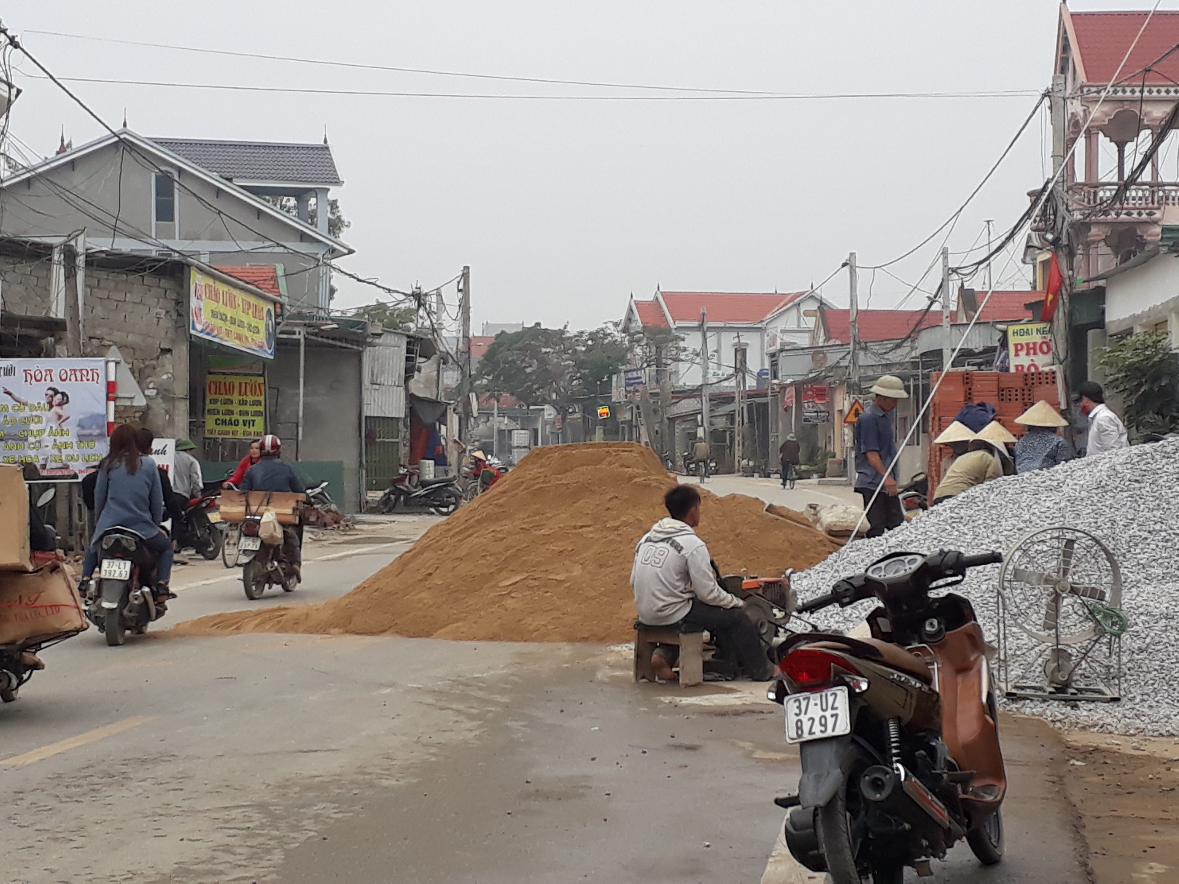 Người dân vô tư biến lòng đường quốc lộ 48 đoạn qua xóm 13, xã Sơn Hải (Quỳnh Lưu) thành nơi tập kết vật liệu xây dựng. Ảnh:Tân Bảo