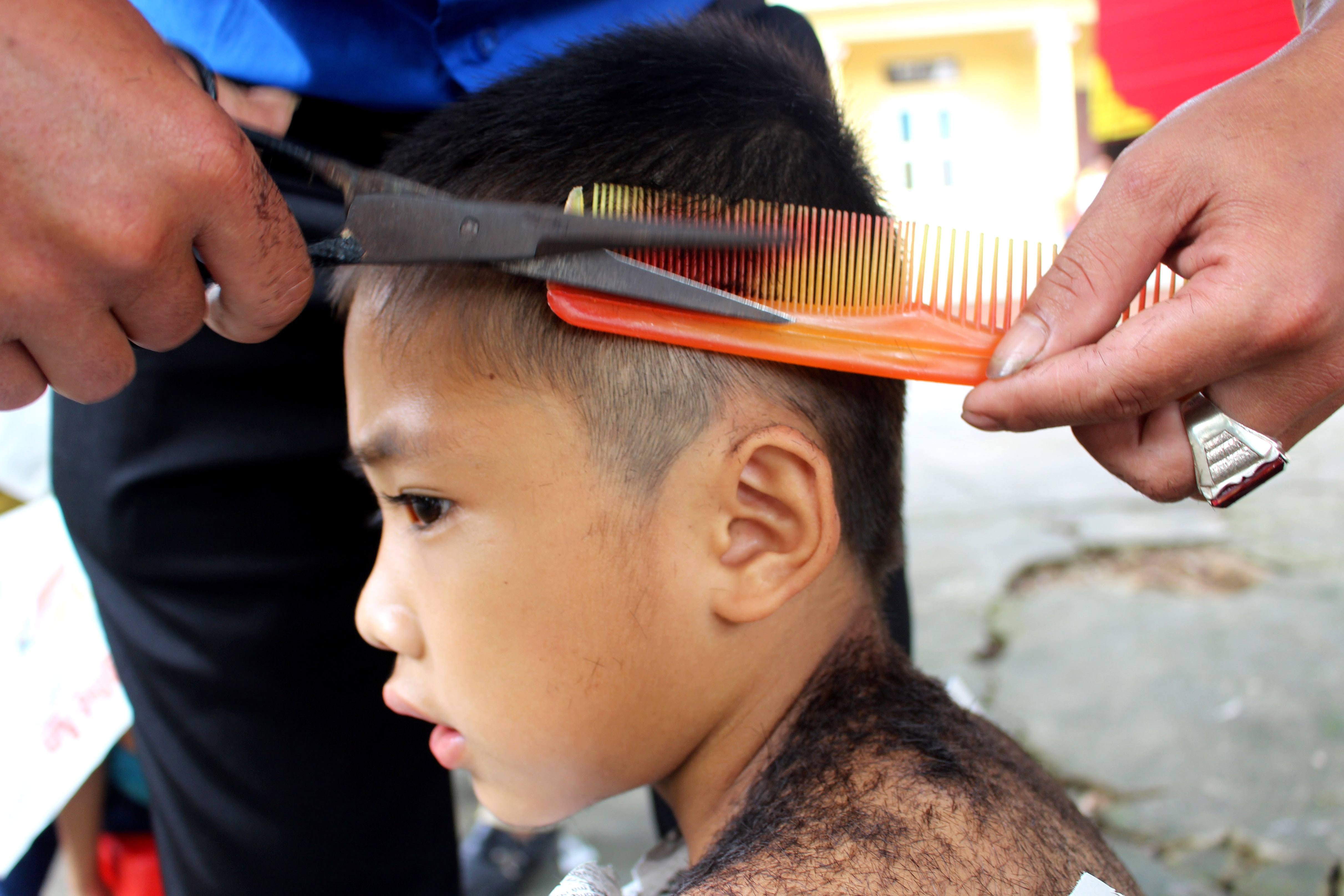 Nhiều thợ cắt tóc chuyên nghiệp tham gia buổi cắt tóc thiện nguyện tại trường tiểu học Thanh Phong. Ảnh: Huy Thư