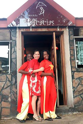 Chị Hương và hai nhân viên mặc áo dài hình cờ đỏ sao vàng trước nhà hàng Acacias. Ảnh: NVCC
