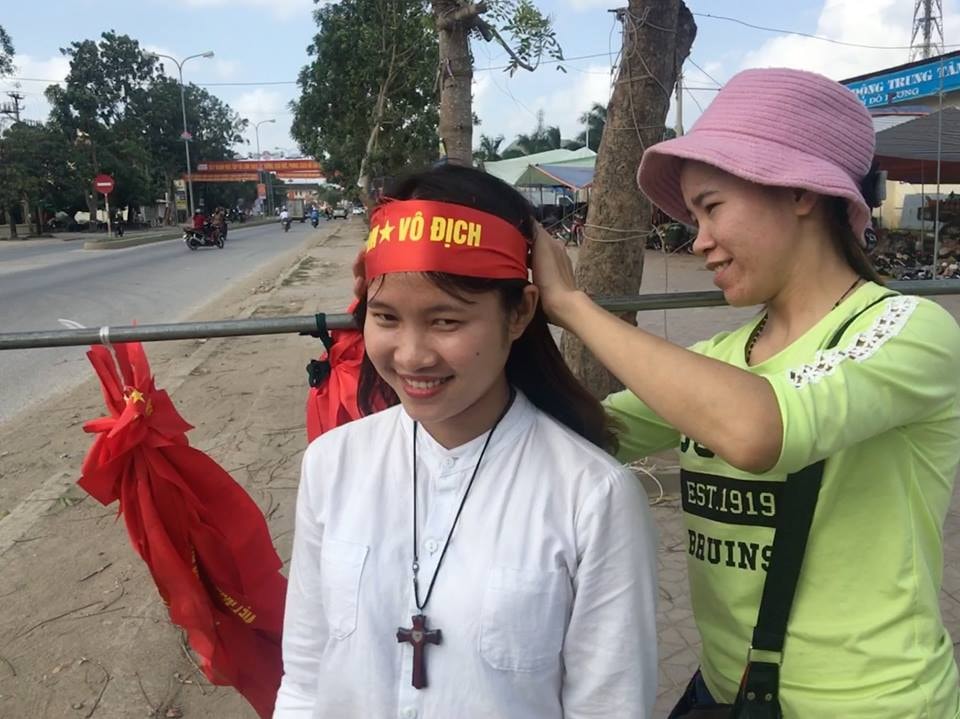Thanh thiếu niên tranh thủ mua các dải buộc đầu để cổ vũ cho đội tuyển Việt Nam. Ảnh Lê Ngọc Phương