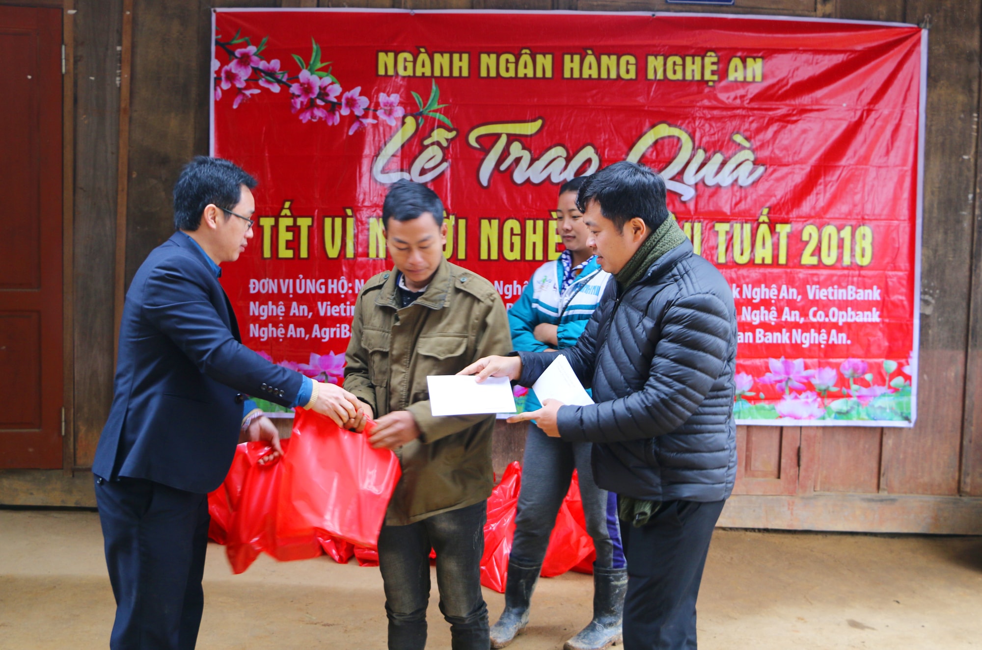 Đại diện các Ngân hàng thương mại tham gia đoàn công tác trao 120 suất quà cho bà con hộ nghèo xã Nậm Càn, Kỳ Sơn. Ảnh: Nguyễn Hải