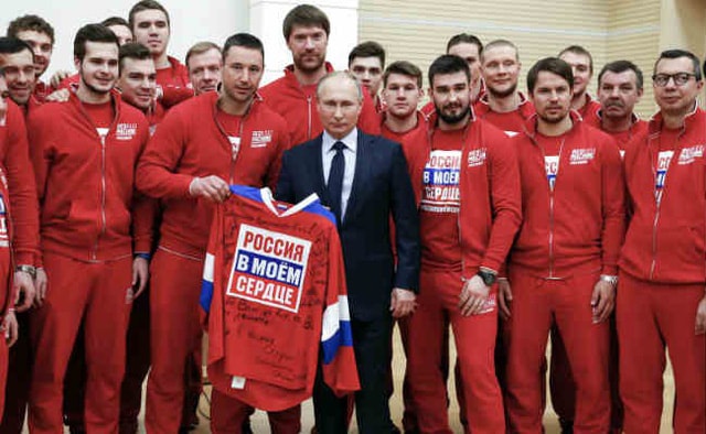 Tổng thống Putin chụp hình với các vận động viên đội khúc côn cầu Nga trong cuộc gặp trước thềm Thế vận hội. Ảnh: AFP
