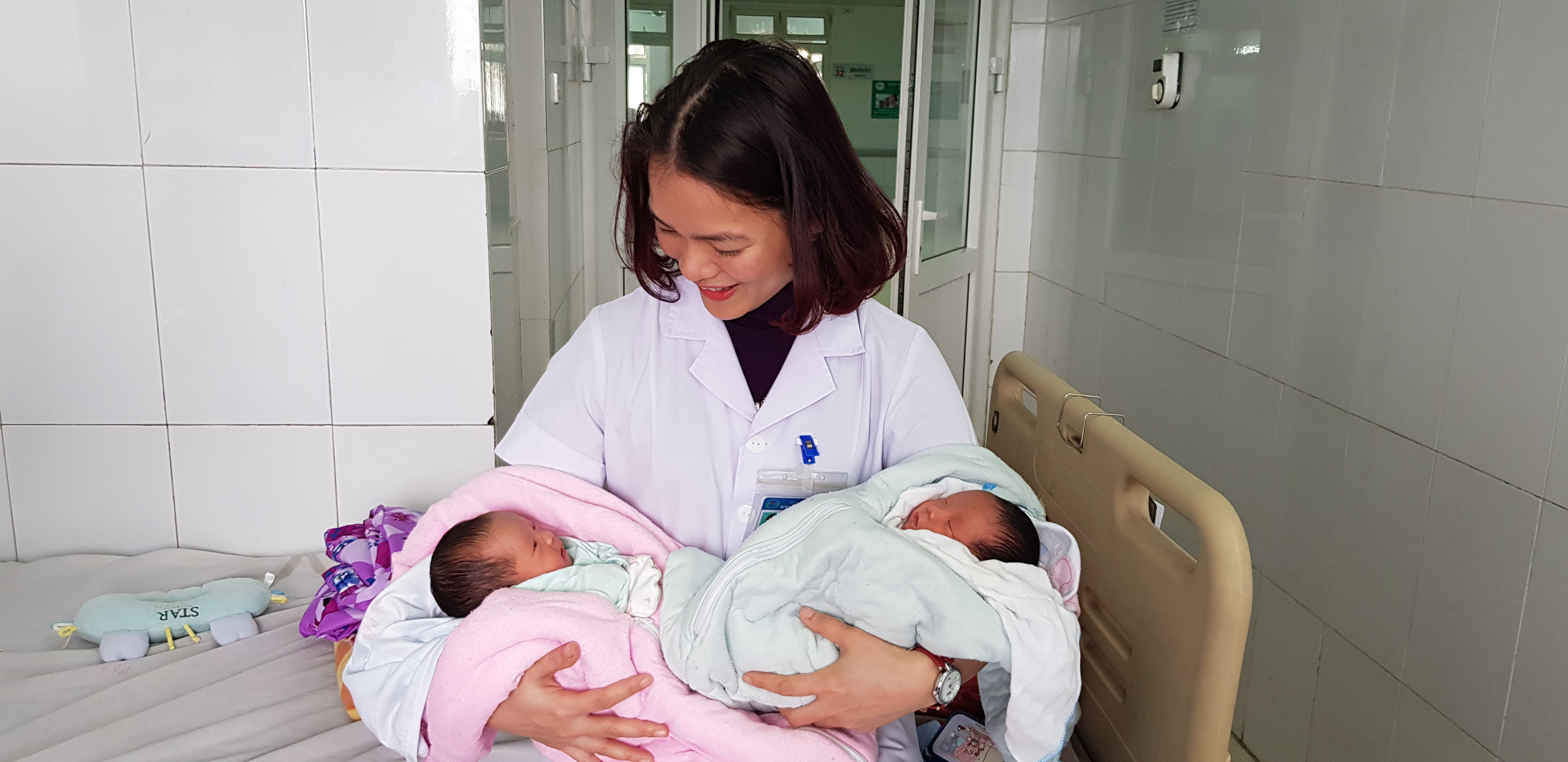 2 em bé khỏe mạnh được nữ y tá chăm sóc sau sinh. Ảnh: Hoàng Yến