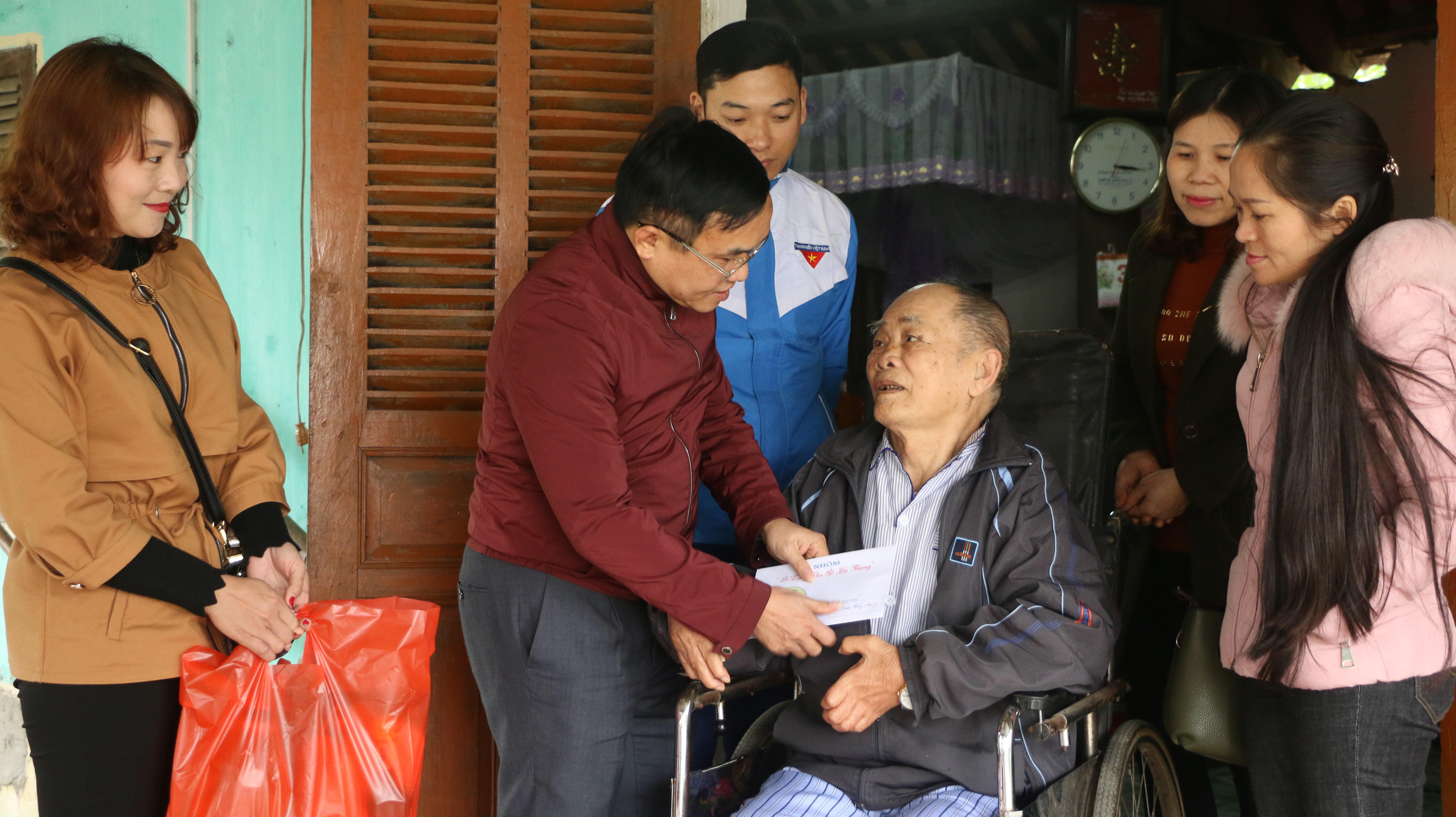 Đồng chí Ngọc Kim Nam - Chủ tịch UBND huyện cùng các thành viên nhóm “Đô lương Chia sẻ yêu thương” trao tặng quà ông Nguyễn Hoàng Thưởng, thương binh 1/4 ở xã Thịnh Sơn.