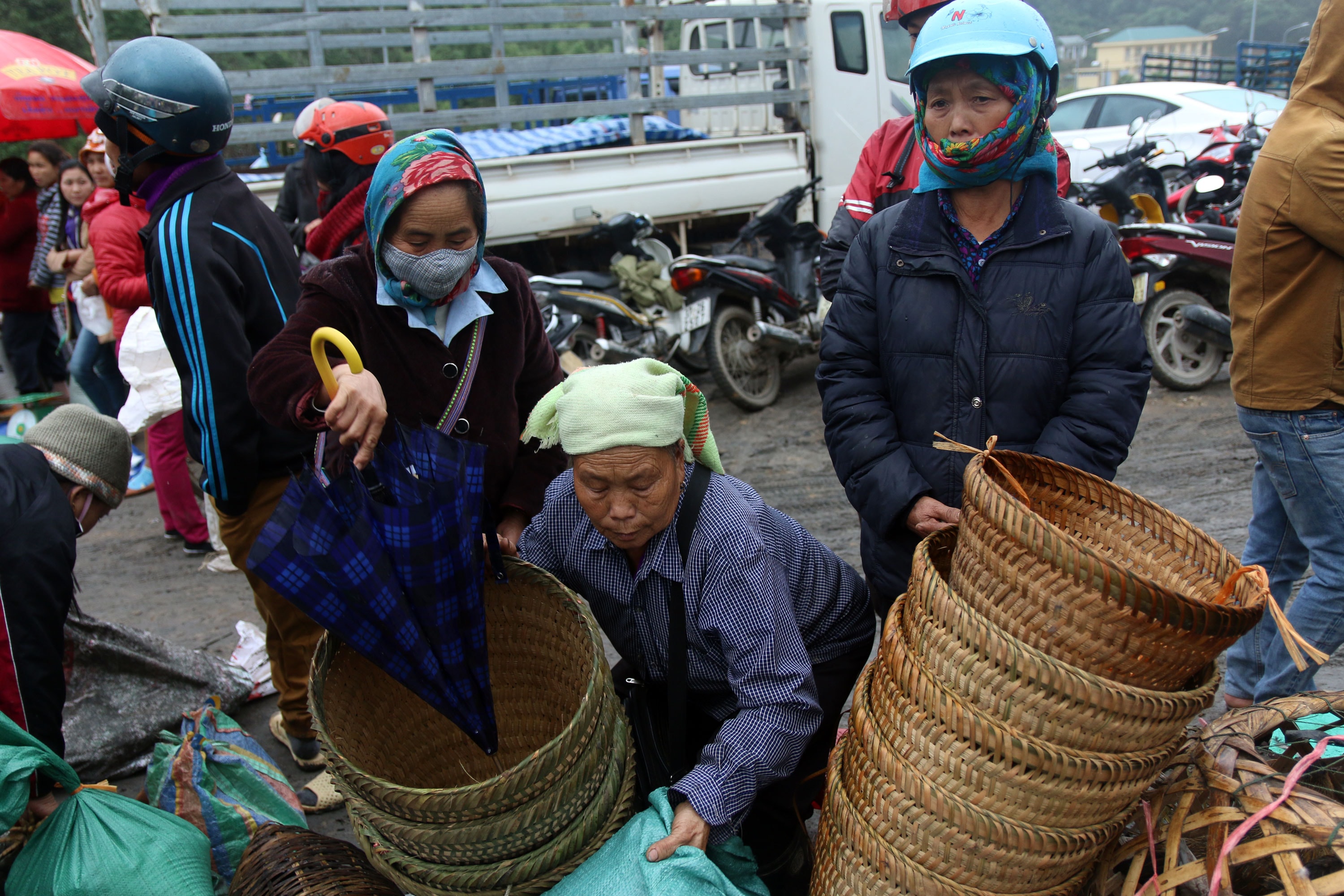 Phụ nữ người Mông mang bế đi bán dịp Tết với chiếc khăn quấn kín vì giá lạnh. Ảnh: Đào Thọ
