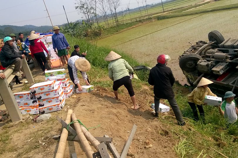 Người dân đang giúp chủ xe chuyển số sữa lên đường. Ảnh Huy Thư