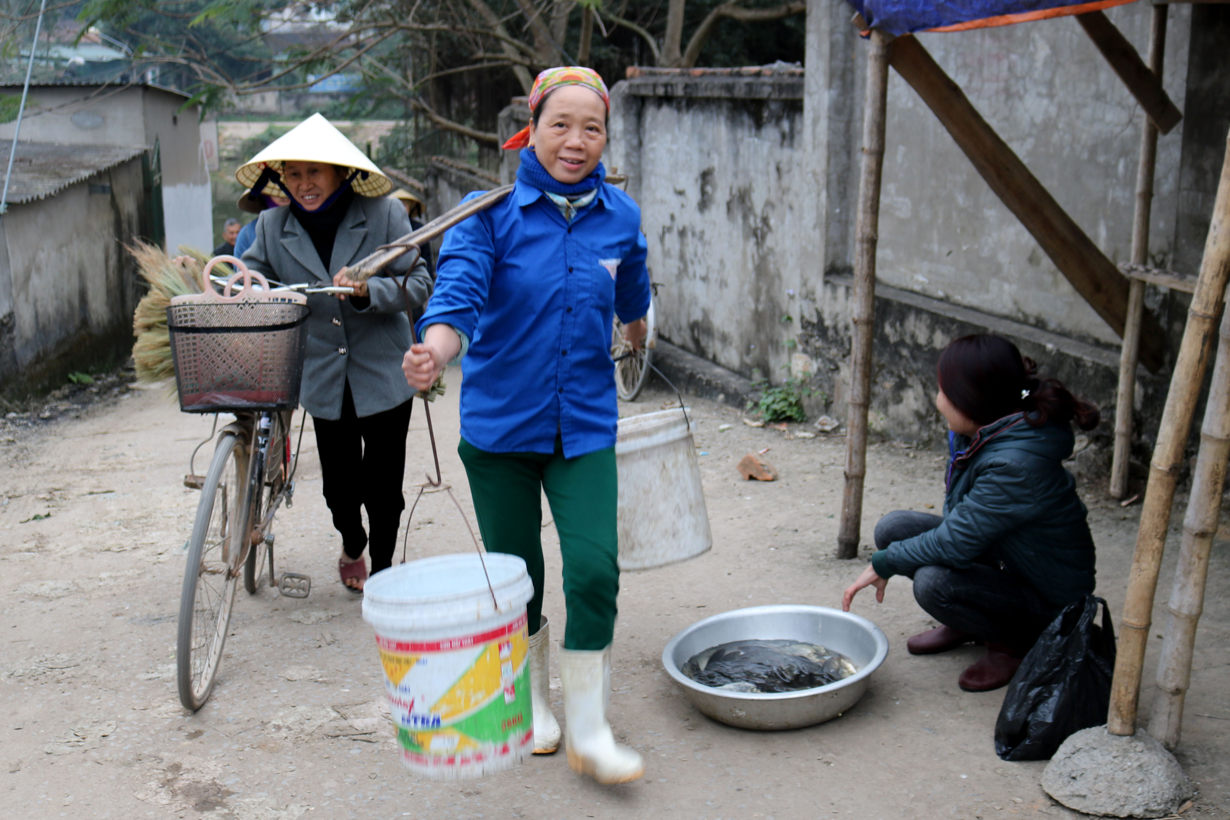 Do bán cá chép để cúng, nên cần nguồn nước sạch, ngày này ở chợ quê xuất hiện thêm dịch vụ gánh nước “truống cá”. Ảnh: Huy Thư