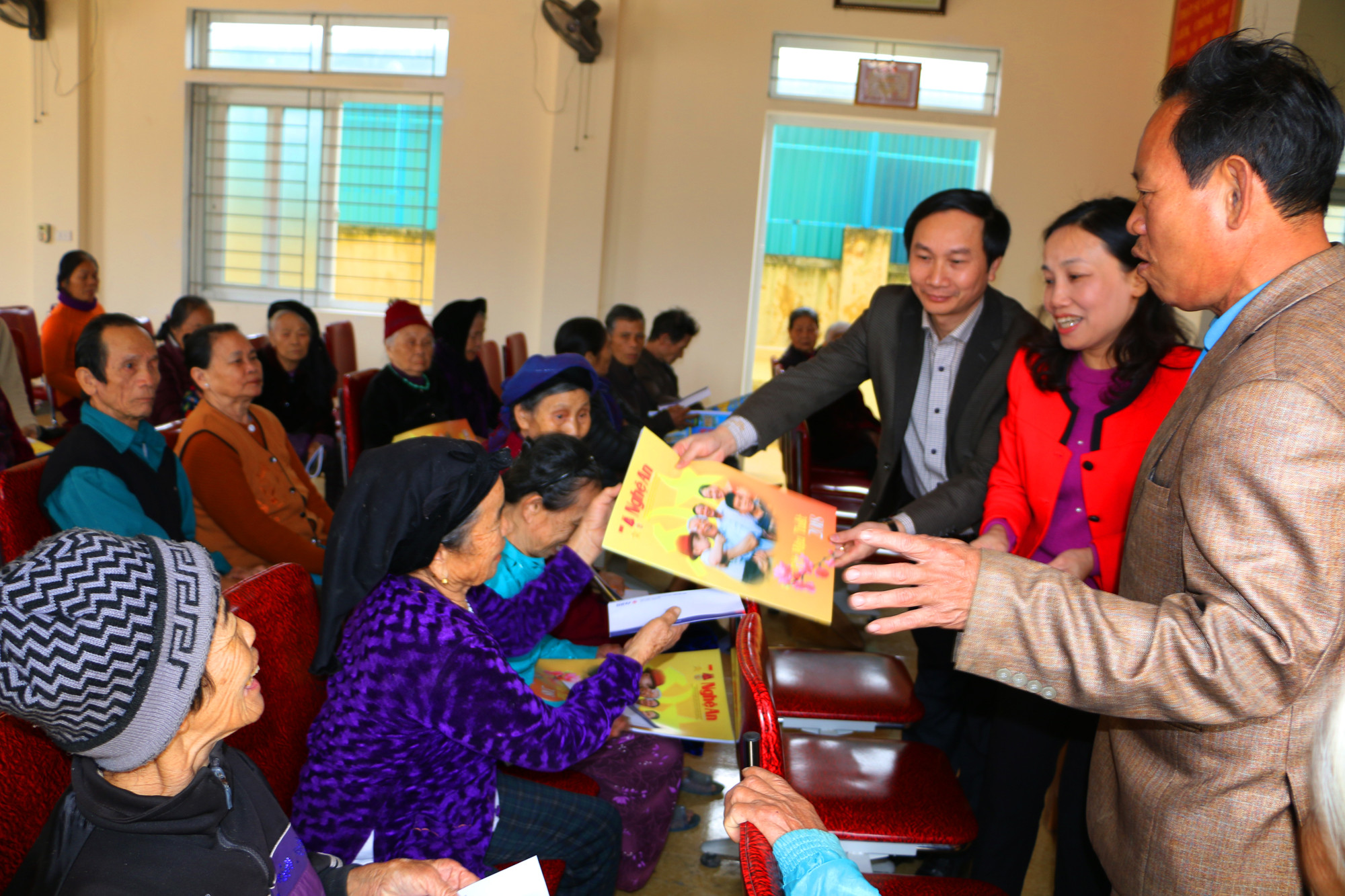 Cùng với trao tiền quà Tết, đại diện Báo Nghệ An và BIDV Nghệ An còn trao tặng các hộ ấn phẩm Báo Nghệ An xuân Mậu Tuất. Ảnh: Nguyễn Hải