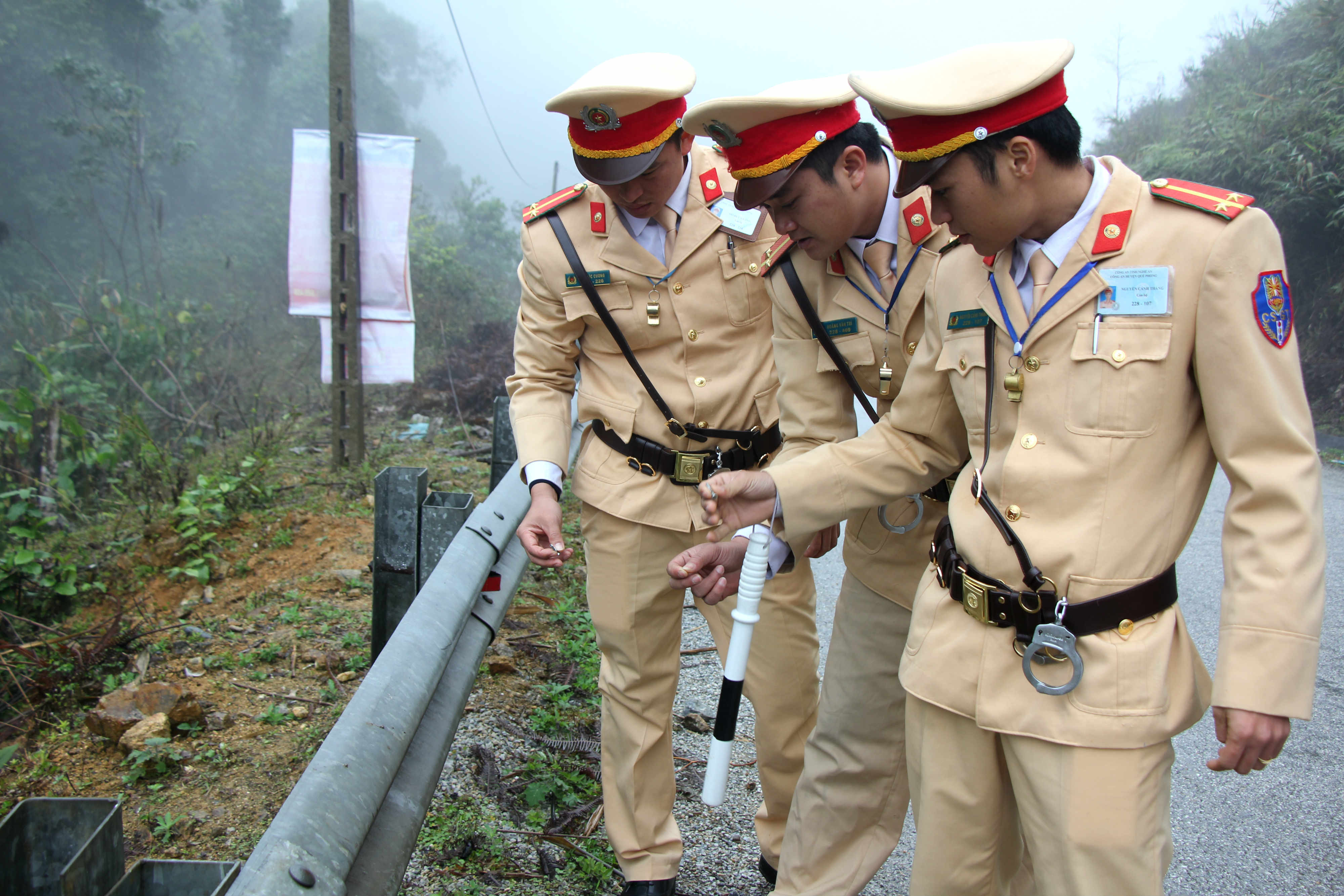 Đội tuần tra CSGT - Công an huyện Quế Phong rà roát, gom nhặt đinh tại km266 Quốc lộ 16 thuộc địa phận xã Châu Thôn. Ảnh: Hùng Cường