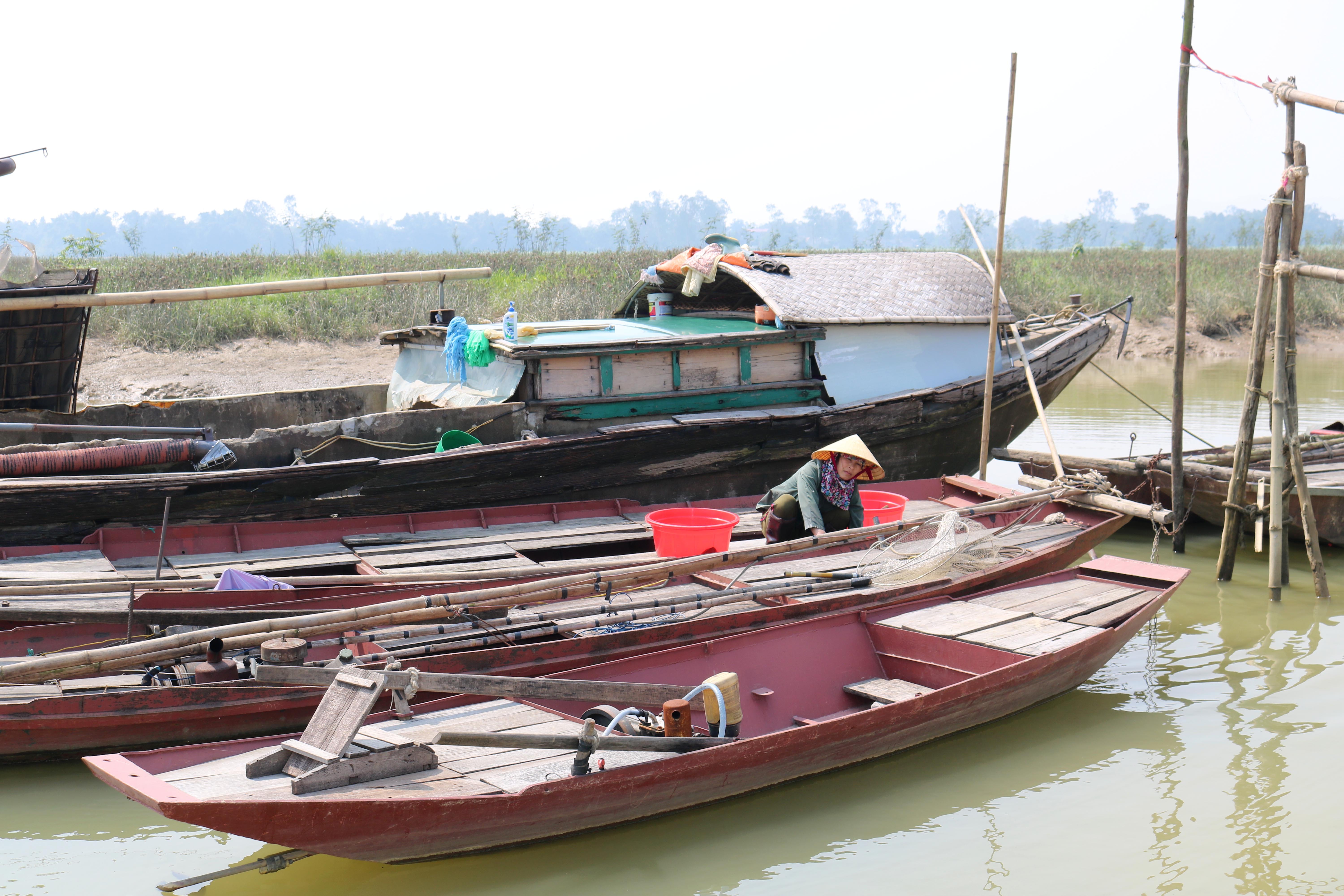 Người phụ nữ làng chài Thanh Sơn, xóm 16, xã Hưng Long (Hưng Nguyên) đang chùi rửa thuyền để đón tết. Ảnh: Huy Thư