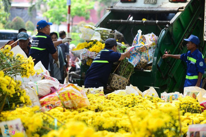 Công nhân môi trường đưa hoa lên xe rác. Ảnh: Internet.