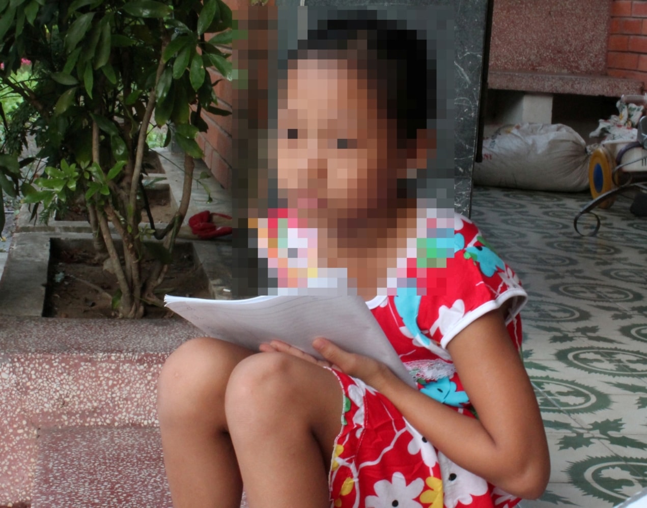 Cháu Nguyễn Thanh Tr., con của tử tù Nguyễn Khắc Long bên lá thư gửi cha. Ảnh: H.T