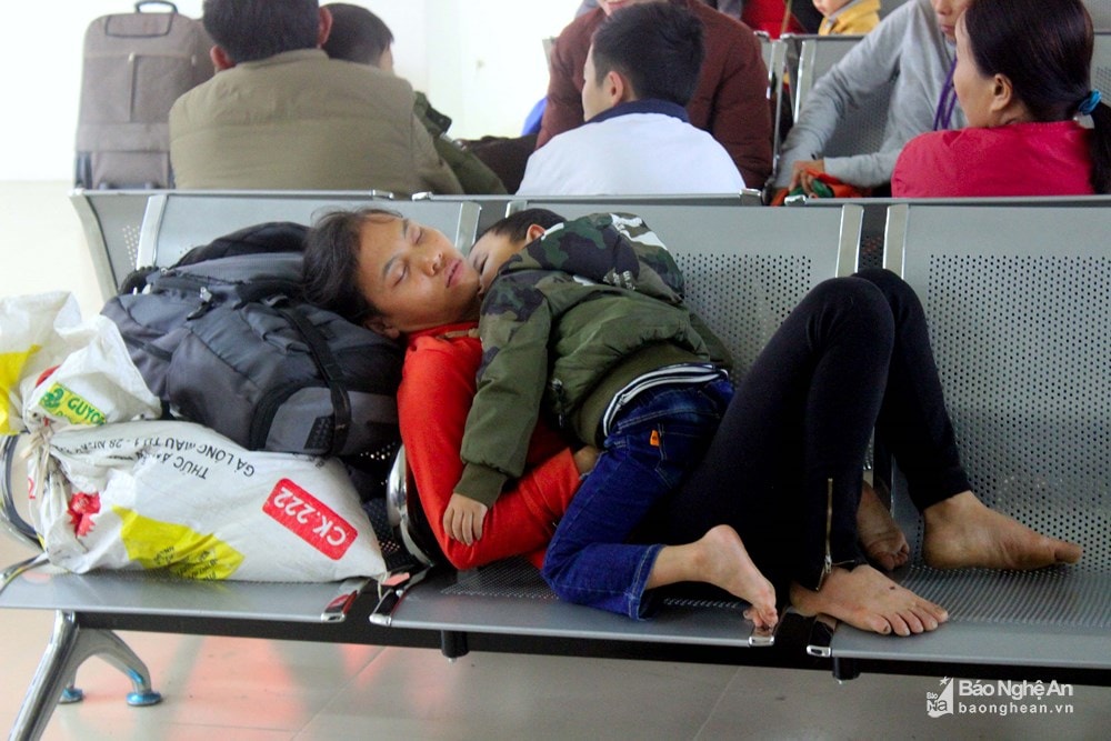 Hai mẹ con công nhân làm việc phía Nam với đống hành lý ngủ thiếp đi tại ga Vinh trong lúc chờ tàu. Ảnh: tư liệu