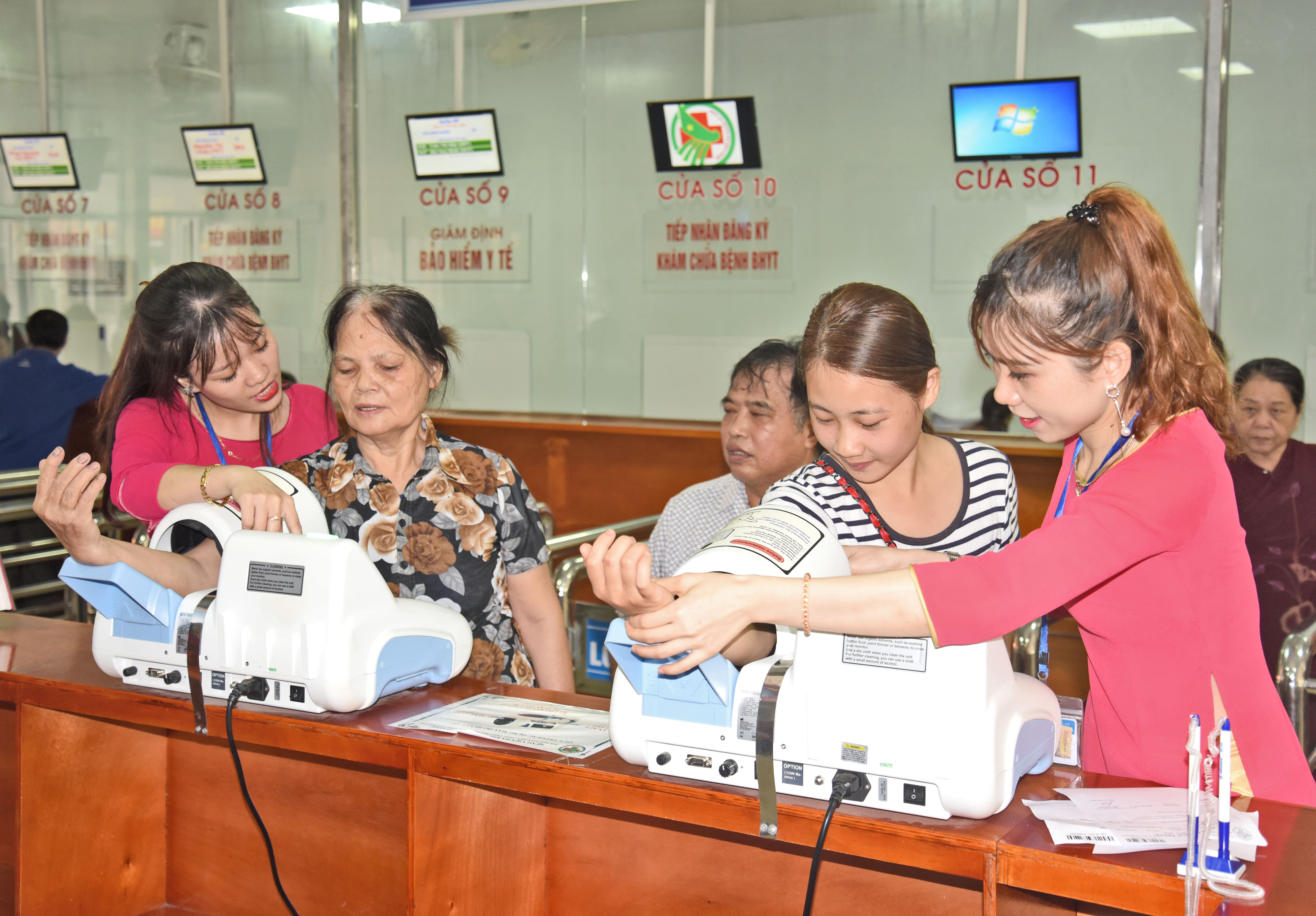 Nhân viên Bệnh viện Đa khoa thành phố Vinh hướng dẫn đo huyết áp cho người dân. Ảnh: P.V