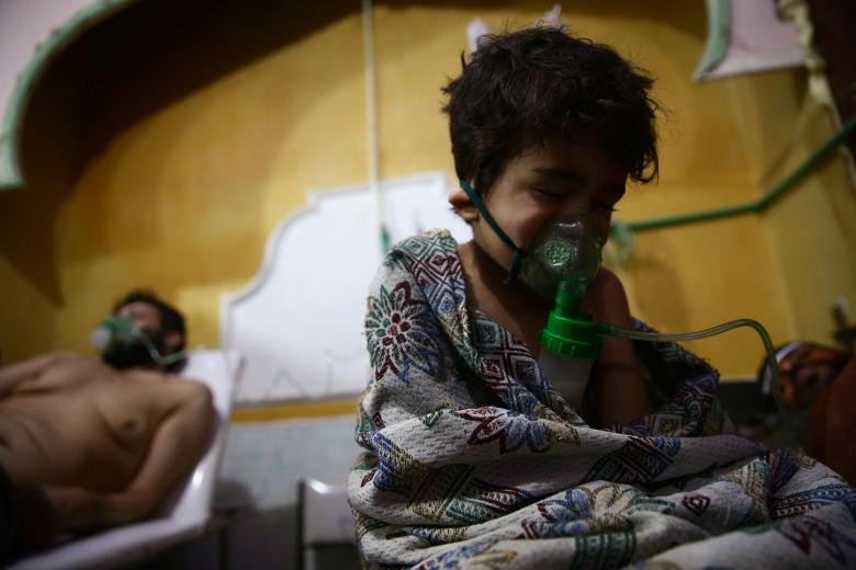 Một đứa trẻ và một người đàn ông được nhìn thấy trong bệnh viện ở thị trấn Douma, Đông Ghouta, Damascus, ngày 25 tháng 2.