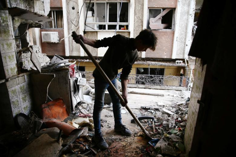 Một thanh niên làm sạch ngôi nhà bị hư hại ở thị trấn Douma, Đông Ghouta, Damascus, ngày 25 tháng 2.