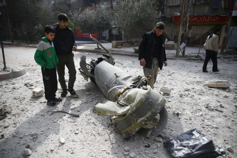 Phần còn lại của một quả tên lửa nằm chỏng chơ trên đường phố ở Douma, đông Ghouta, Damascus, Syria. Ảnh: Reuters.