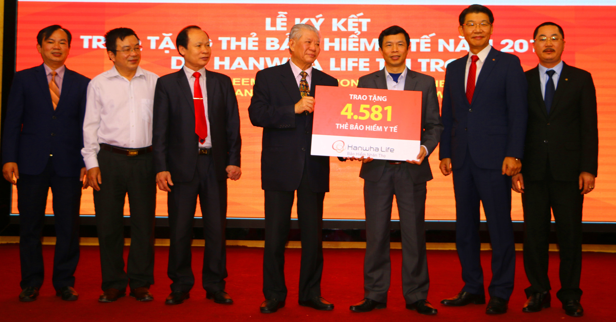 Đại diện Nhà tài trợ trao Biểu trưng hỗ trợ 4.581 thẻ Bảo hiểm Y tế đợt đầu năm 2018 cho ông Vương Quang Minh- Phó Chủ tịch UB MTTQ tỉnh Nghệ An. Ảnh: Nguyễn Hải