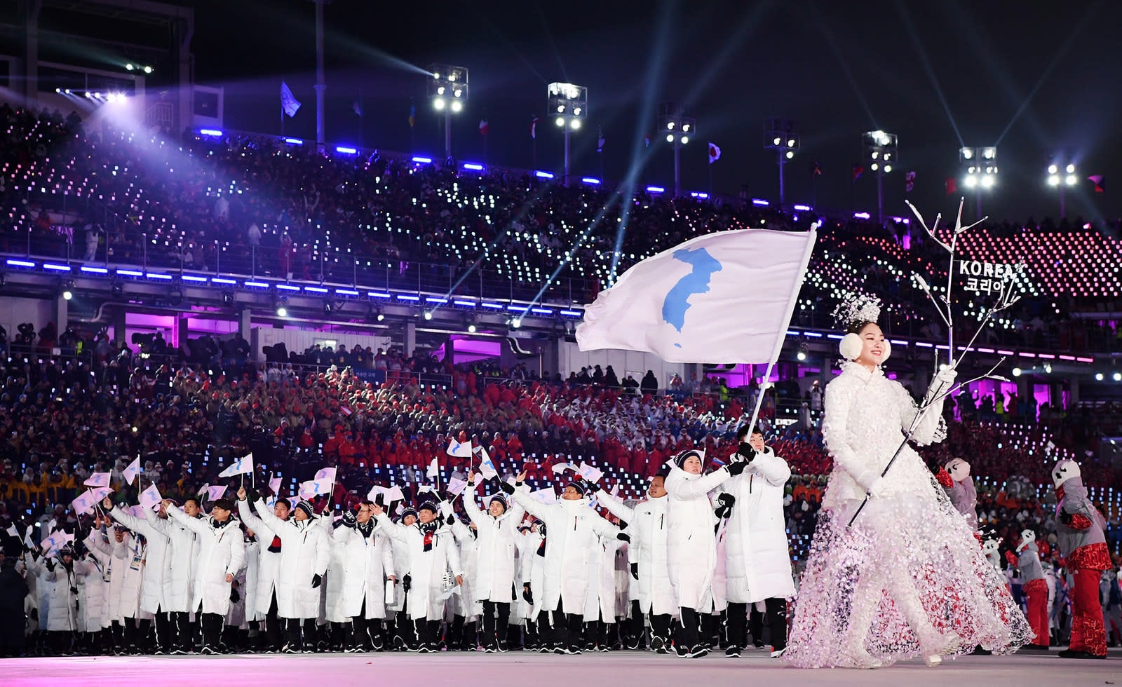 Vận động viên hai miền Triều Tiên diễu hành dưới một lá cờ thống nhất. Ảnh: AFP