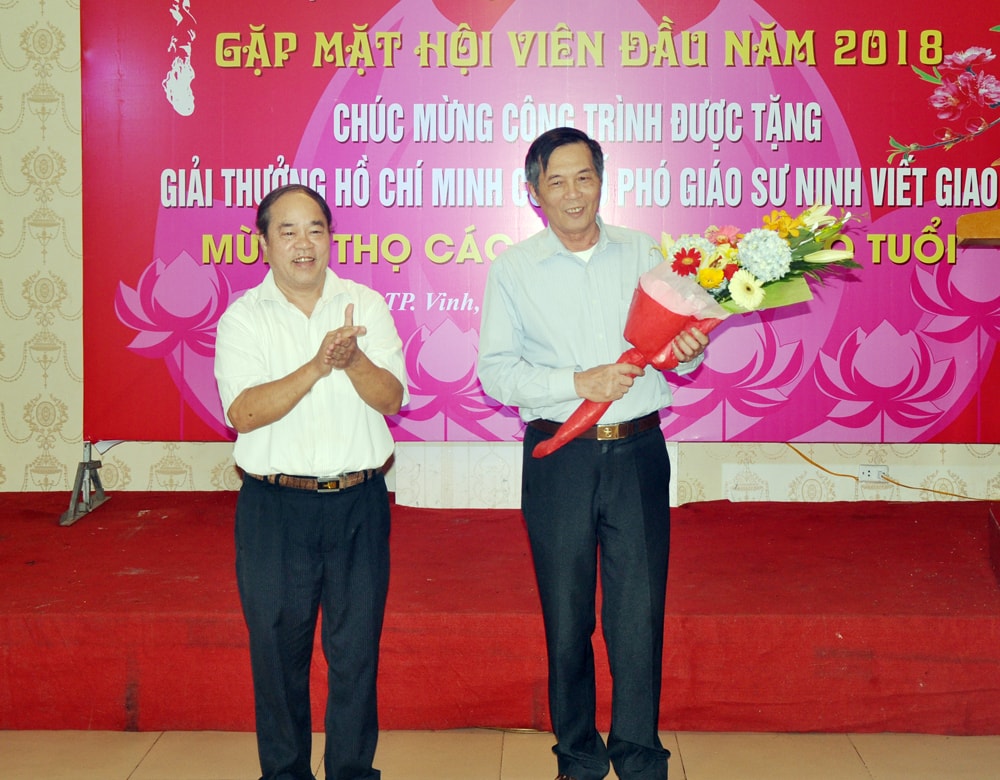 Ông Trần Hữu Đức - Chủ tịch Hội VNDG Nghệ An tặng hoa chúc mừng ông Ninh Quang (con trai cố PGS Ninh Viết Giao). Ảnh: Công Kiên