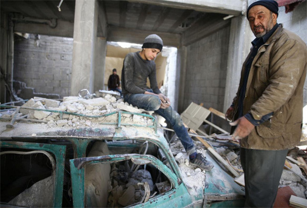 Abu Mohammad Alaya tìm kiếm con trai trong đống đổ nát. Ảnh: Reuters