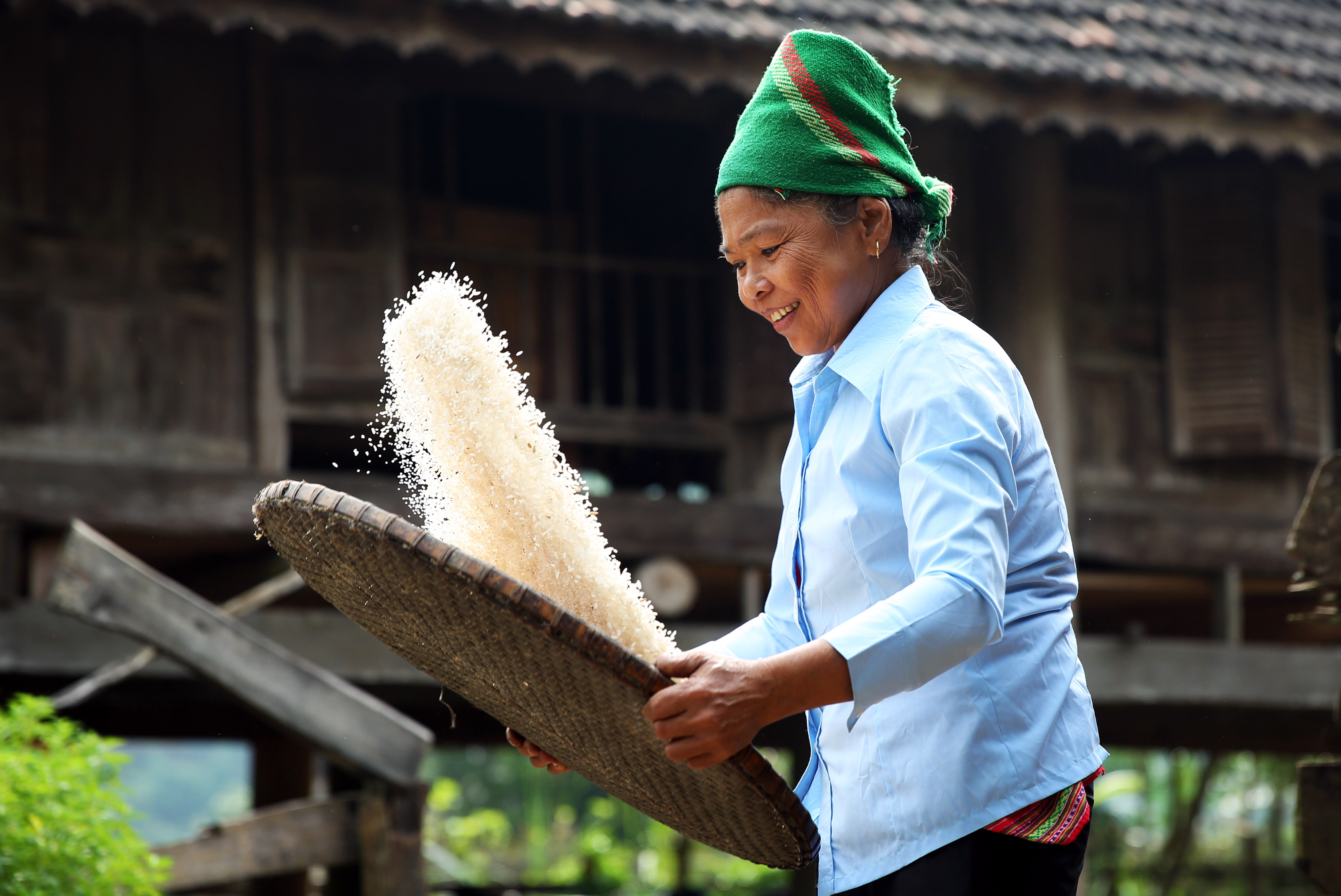 Gạo sau khi giã, người phụ nữ lại dùng nia để sảy gạo. Công việc gắn liền với những buổi sớm mai trước khi lên rẫy. Ảnh : Hồ Phương