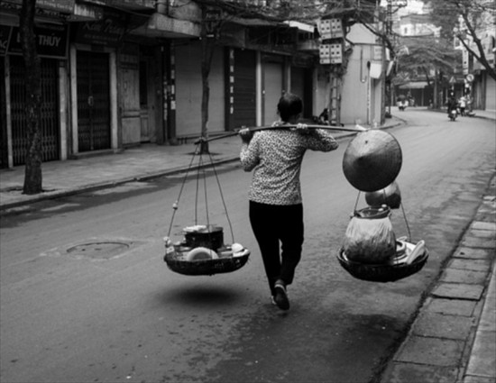 Mẹ gánh đủ thứ trên đôi quang mảnh, cái đòn dài dùng lâu ngày trơn láng, hằn cả vết tay mẹ